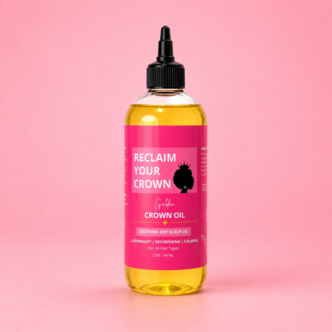 Golden Crown Oil soothing dry scalp oil in a clear 2 oz bottle filled with golden oil, featuring a vibrant pink Reclaim Your Crown label on a soft pink background.